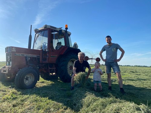 Jan aan het hooien bij de tractor